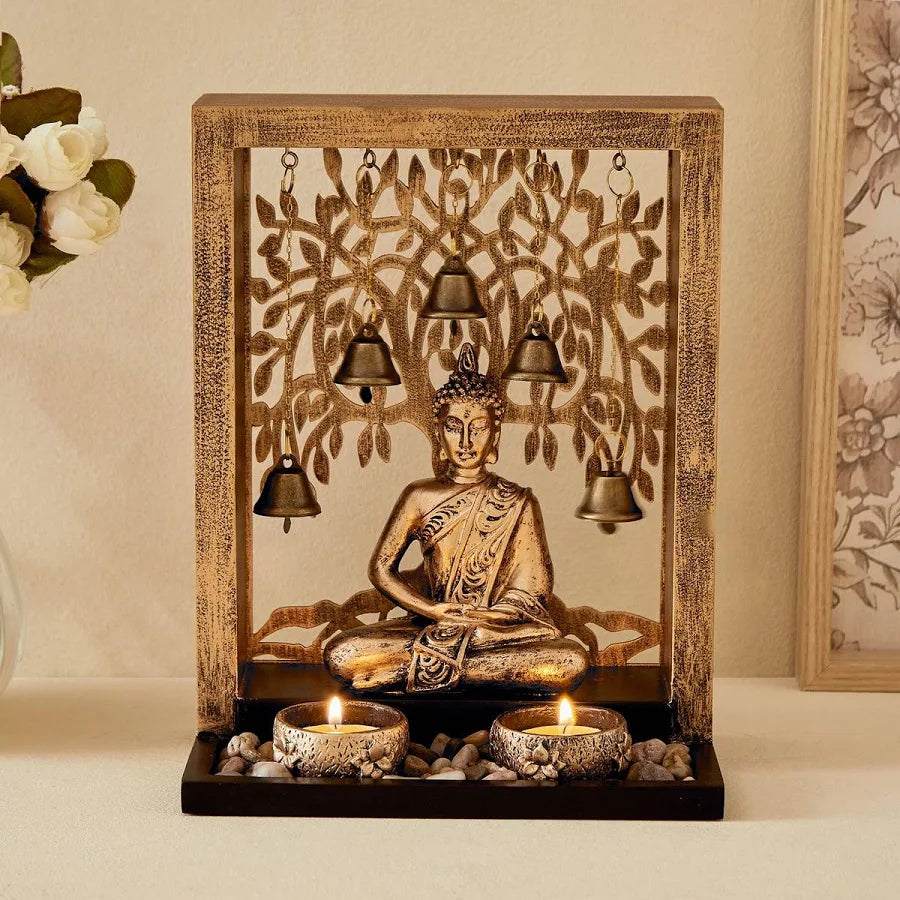 Decorative table lamp with Buddha statue and hanging bells on a wooden base.