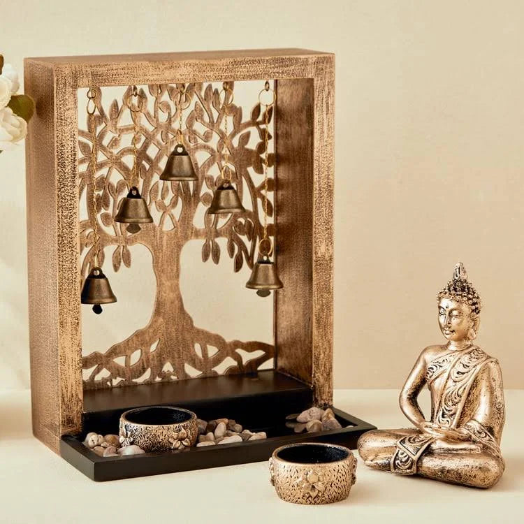 Decorative setting with a tree of life design, candles, and a Buddha statue on a beige background
